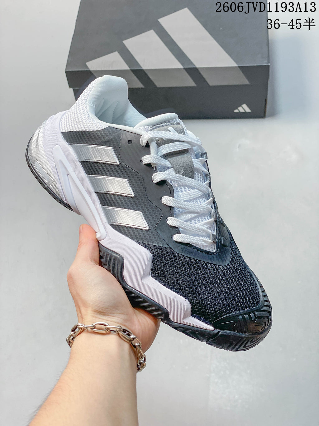 Side view of a gray and white Adidas Barricade 13 tennis shoe