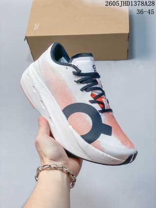 Angled side view of a white and coral On Cloudboom Volt running shoe with dark laces and graphic details.