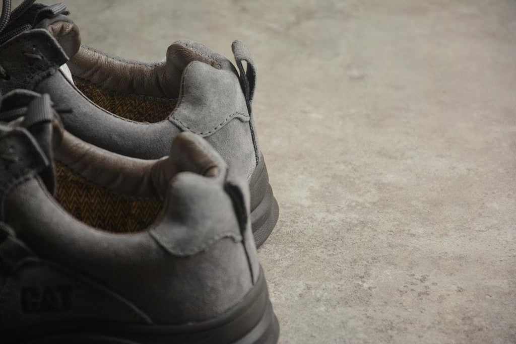 Rear-quarter view of the gray CAT sneakers showing the heel panels and pull tabs.