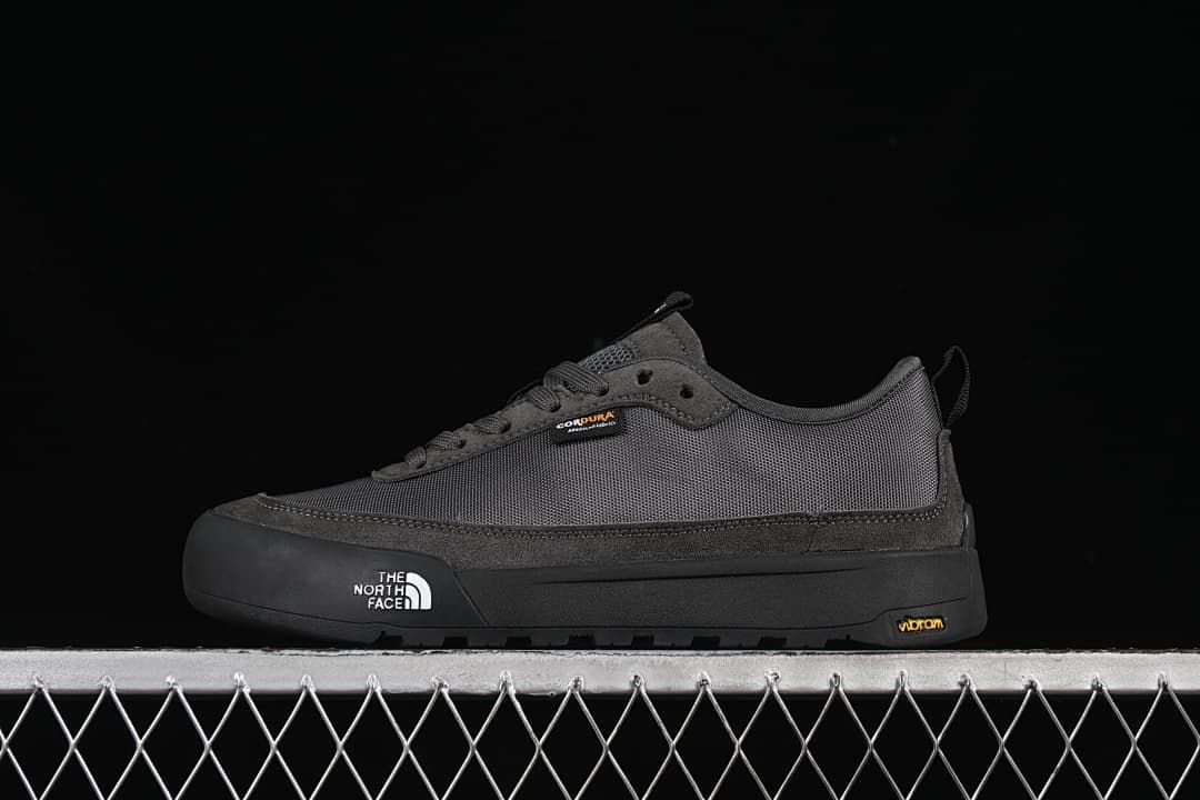 Side view of charcoal grey The North Face low-top sneakers against a black background