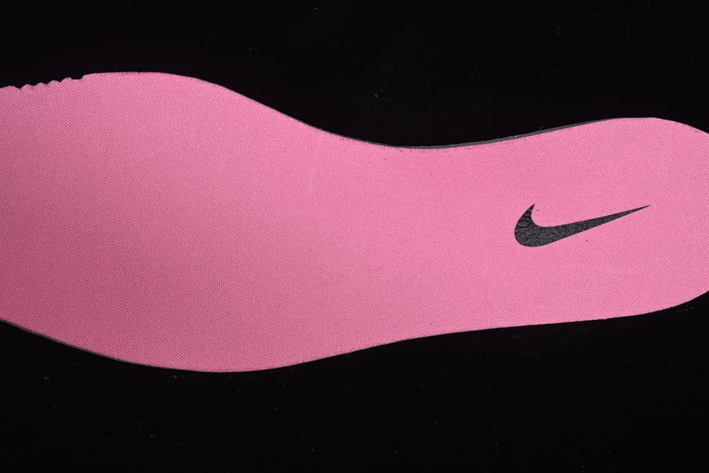 Pink shoe insole with a dark Swoosh logo