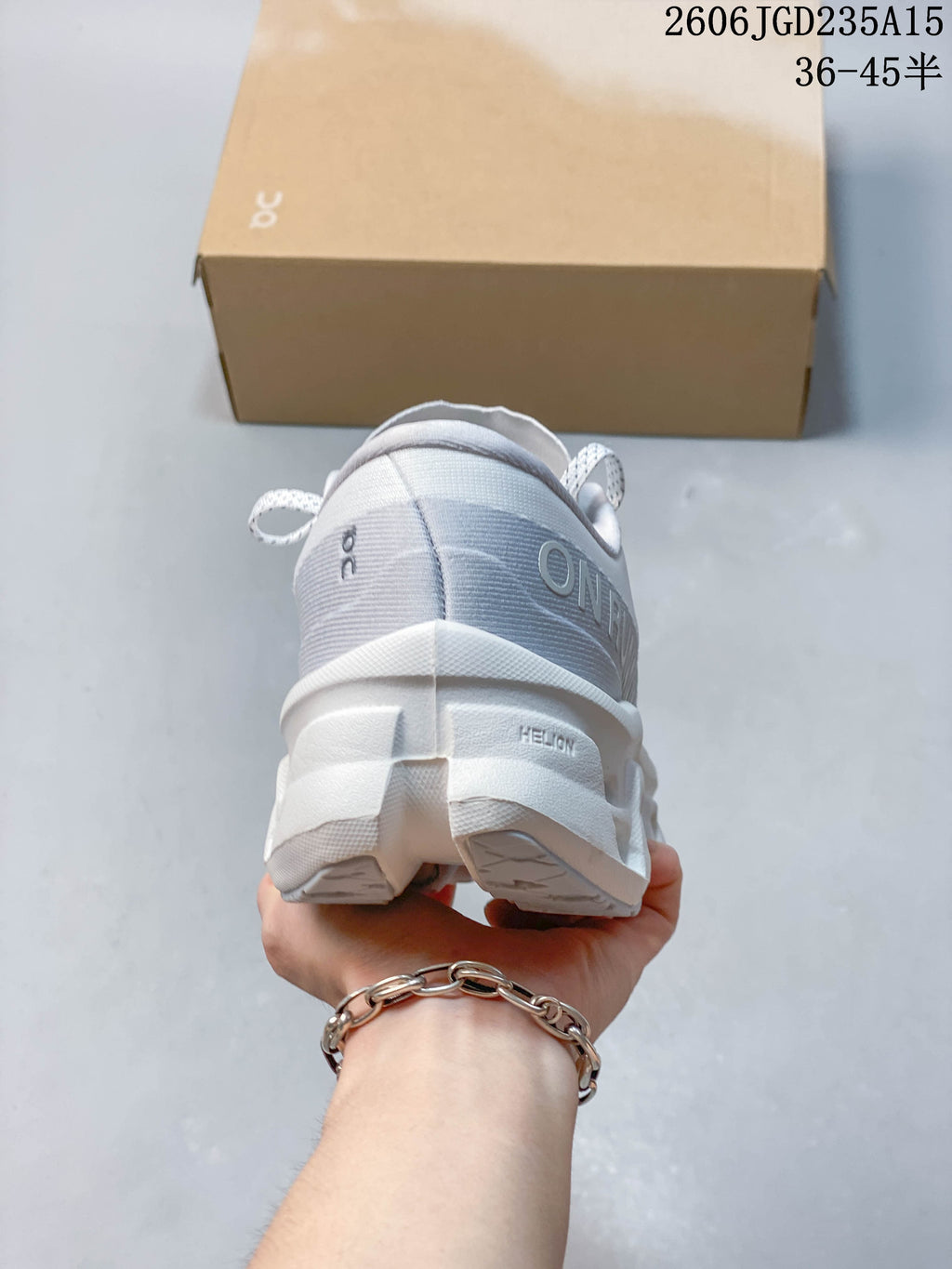 Rear view of a white On Cloudmonster 3 sneaker with gray heel detailing
