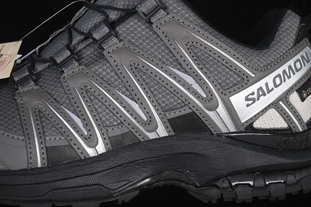Close-up of the gray side overlays, Salomon branding, and black midsole.