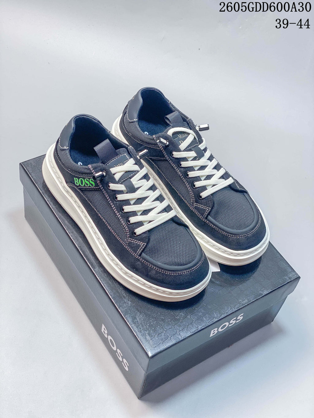 Pair of navy BOSS low-top sneakers with white laces and thick off-white soles, shown on a branded box; image overlay states sizes 39–44.