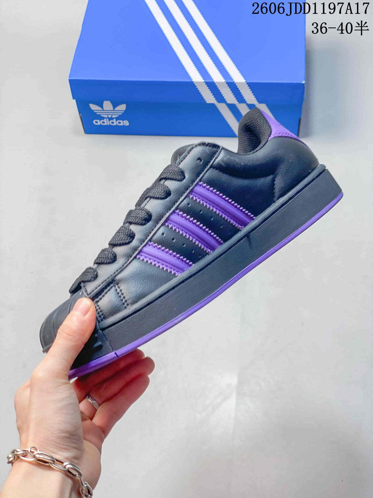 Side view of a charcoal-black adidas Superstar ST sneaker with purple stripes and outsole