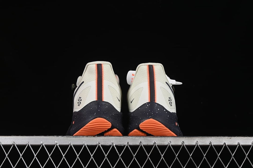 Rear view of the pair showing orange outsole sections and dark speckled midsoles