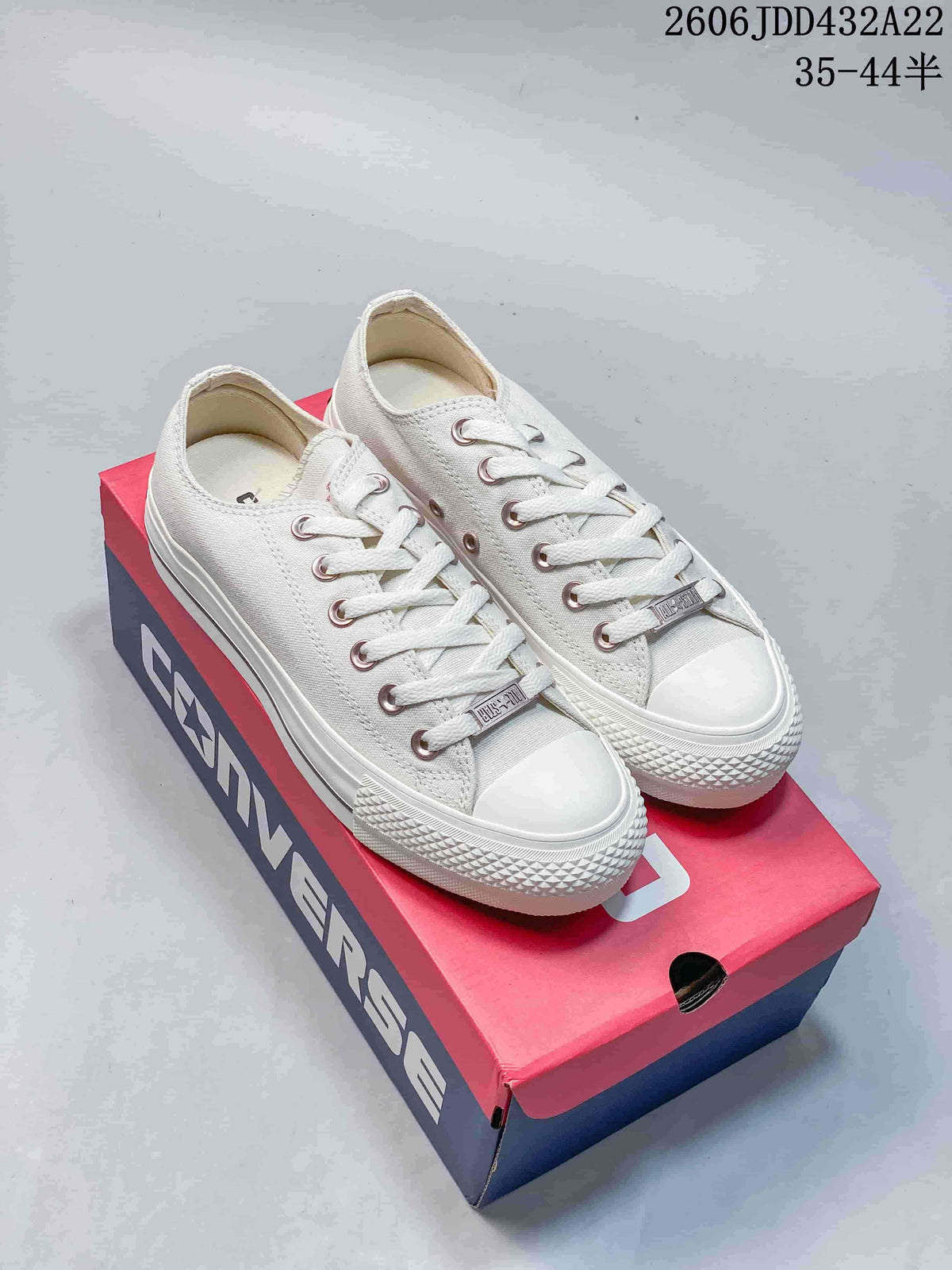 Pair of off-white low-top Converse All Star sneakers with white laces and toe caps