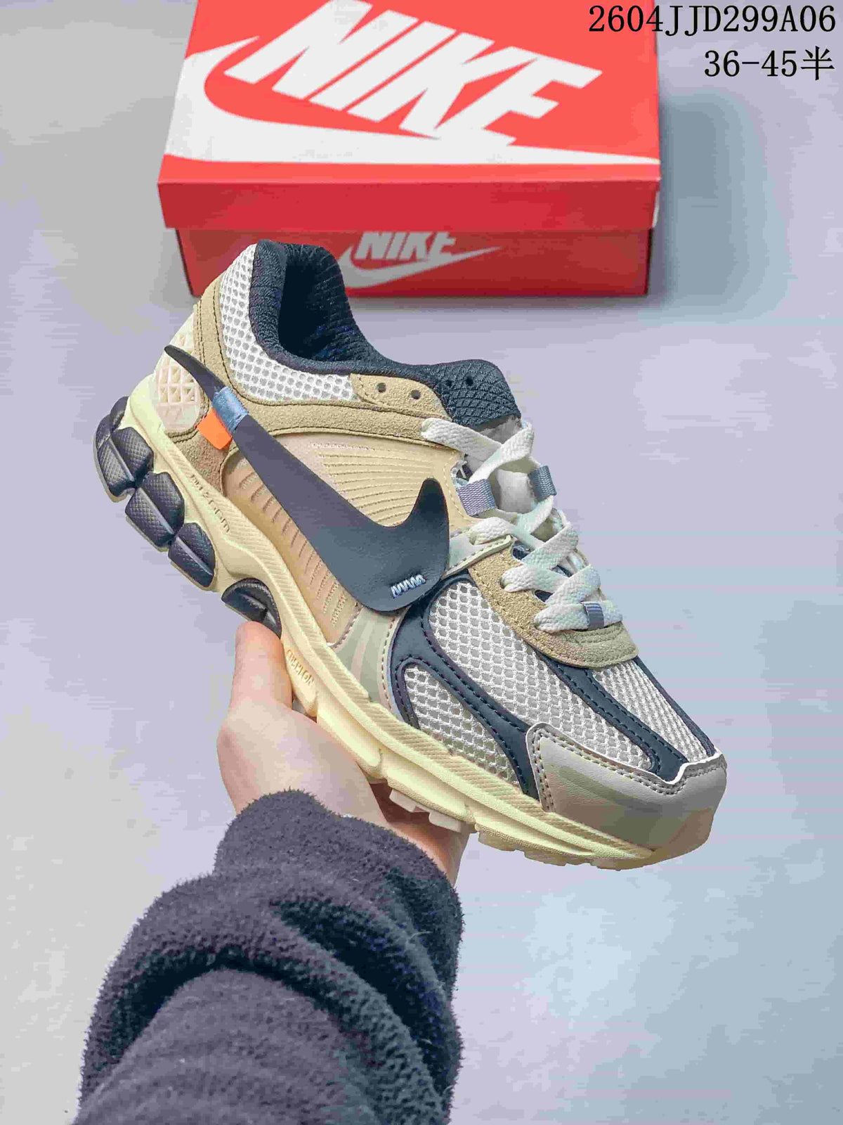 Side view of a light neutral Nike Zoom Vomero 5 sneaker with dark overlays and a pale-toned sole.