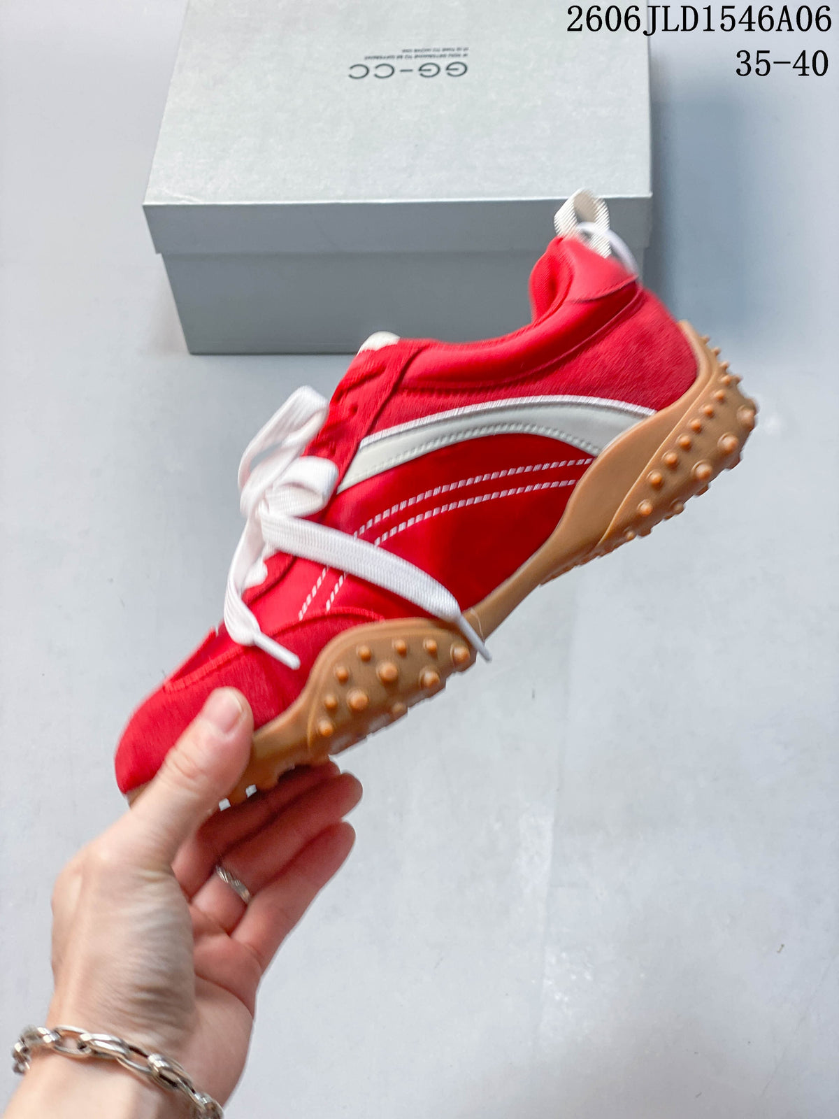 Side view of a red sneaker with white detailing and a gum-colored outsole.