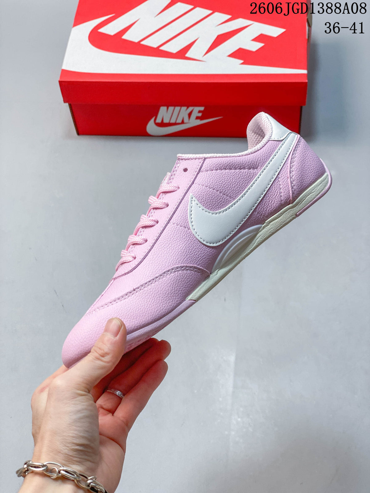 Side profile of the pink low-top sneaker with a white Swoosh