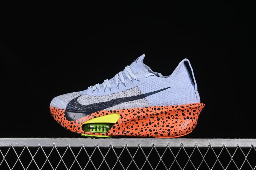 Side view of the shoe with its orange speckled sole and lime heel cushioning detail.