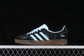 Side view of a black adidas Gazelle Indoor sneaker with light blue stripes and a gum-colored sole