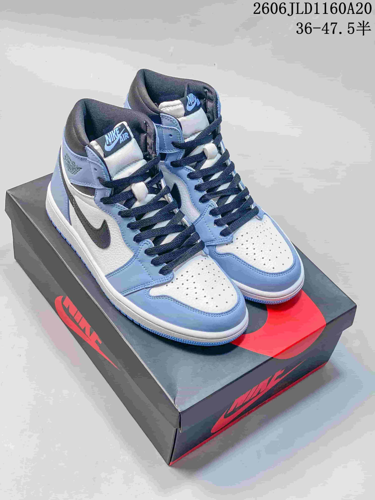 White and light blue Jordan 1 high-top sneakers with dark laces on a shoebox