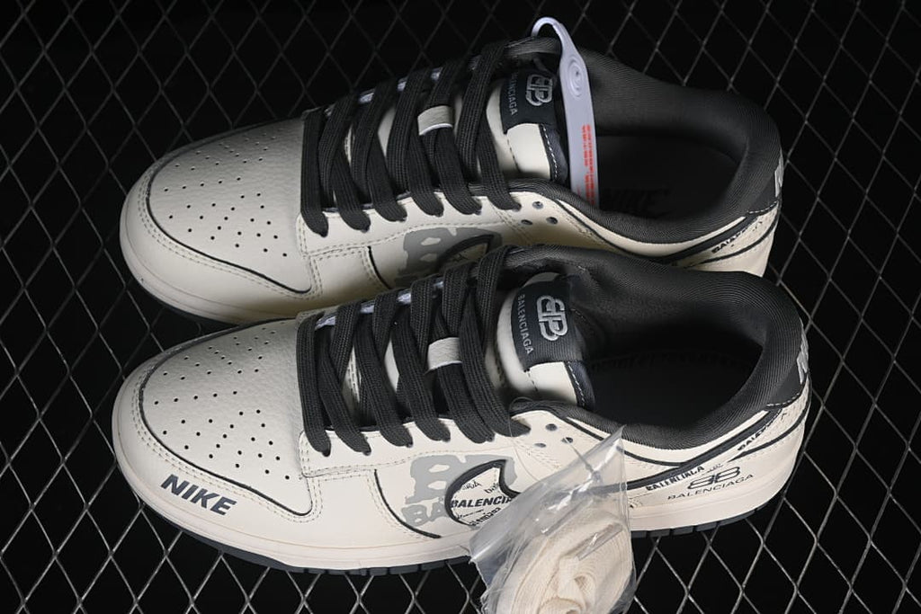 Pair of white and gray Nike SB Dunk Low shoes with black laces and printed details
