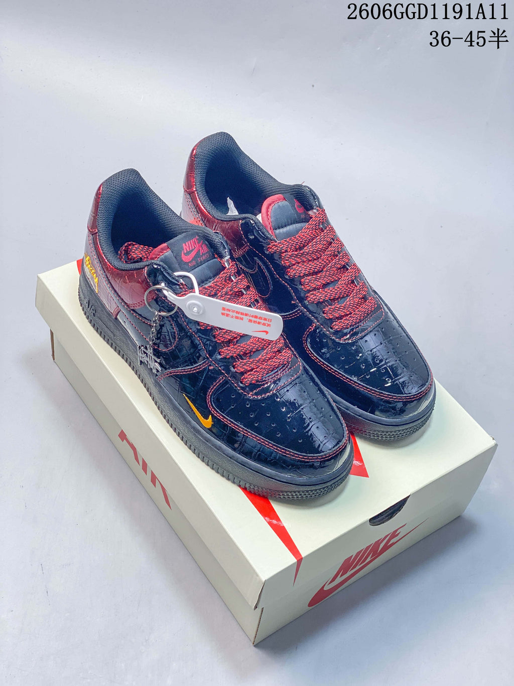 Pair of glossy dark Nike Air Force 1 Low style sneakers with burgundy panels, red-and-black laces, and yellow accents