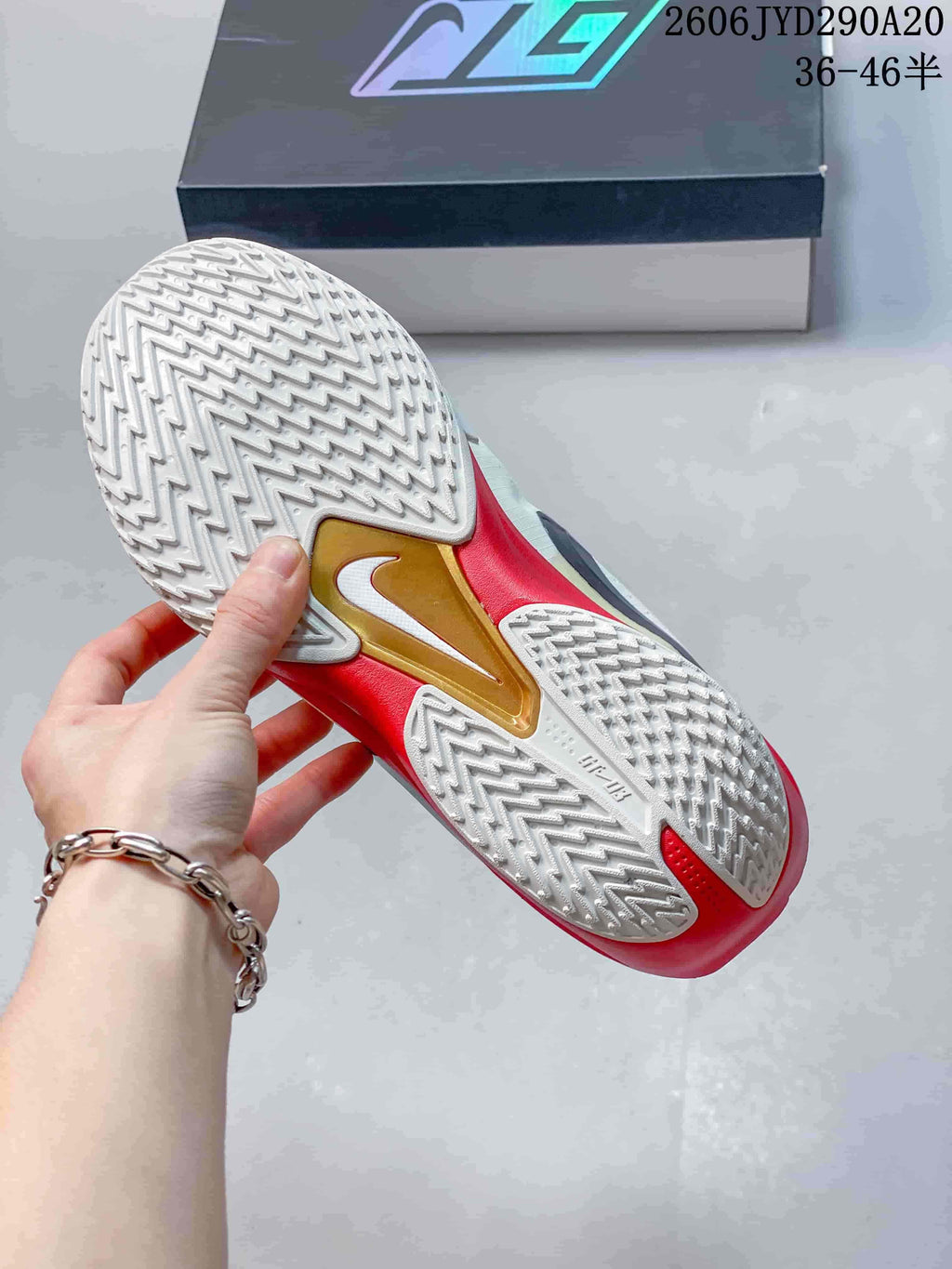 View of the white patterned outsole with red and gold-tone details