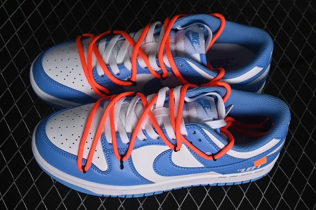 Pair of blue and white low-top sneakers with orange-red overlay laces.
