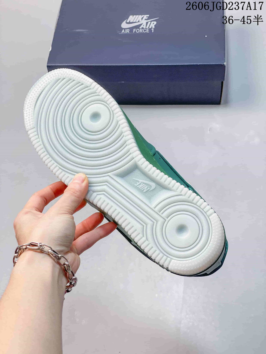 White outsole with circular tread pattern beneath a teal sneaker.