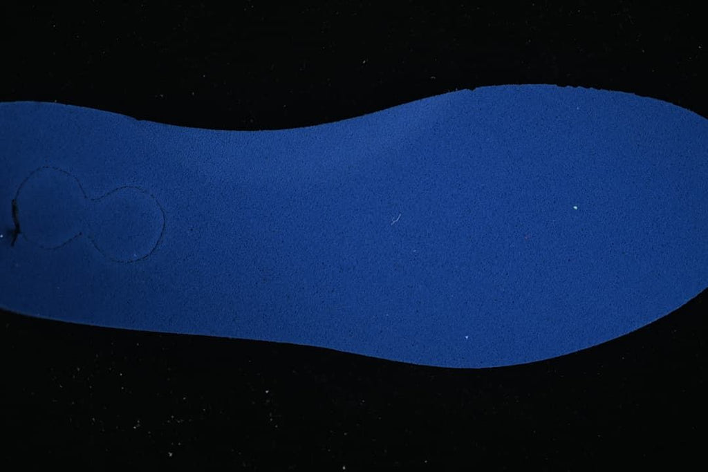 Blue shoe insole shown against a dark background
