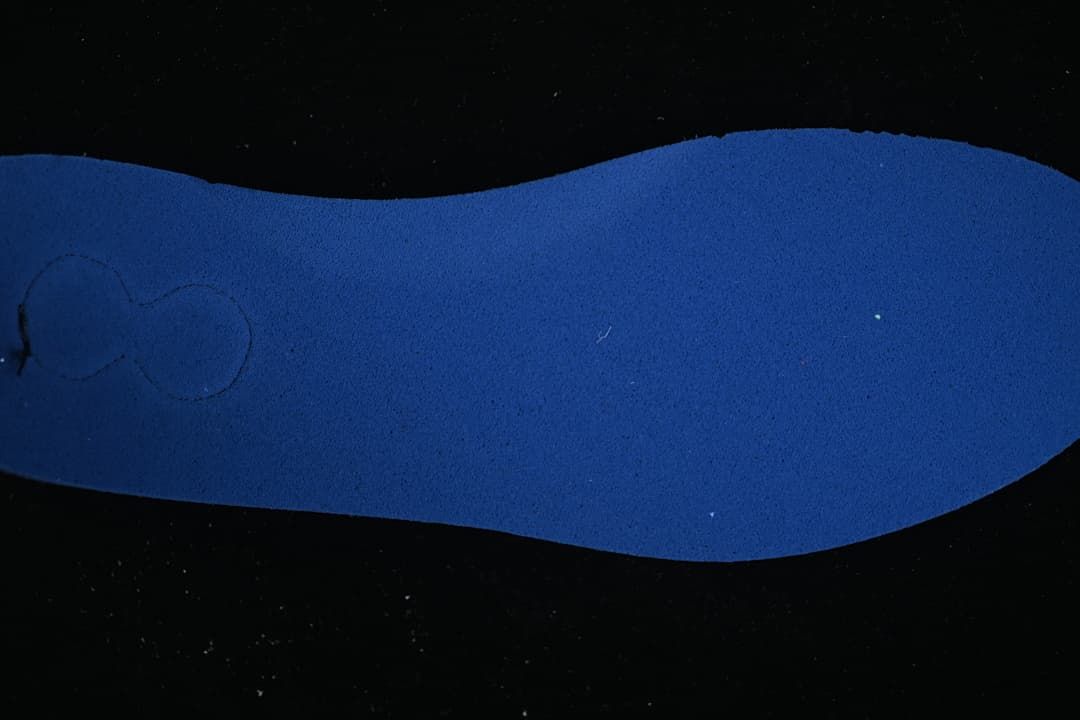 Blue shoe insole shown against a dark background