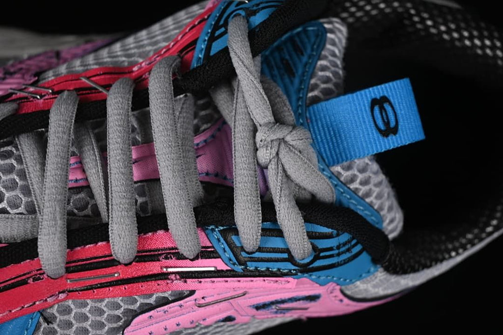 Close-up of grey laces and blue and pink upper details