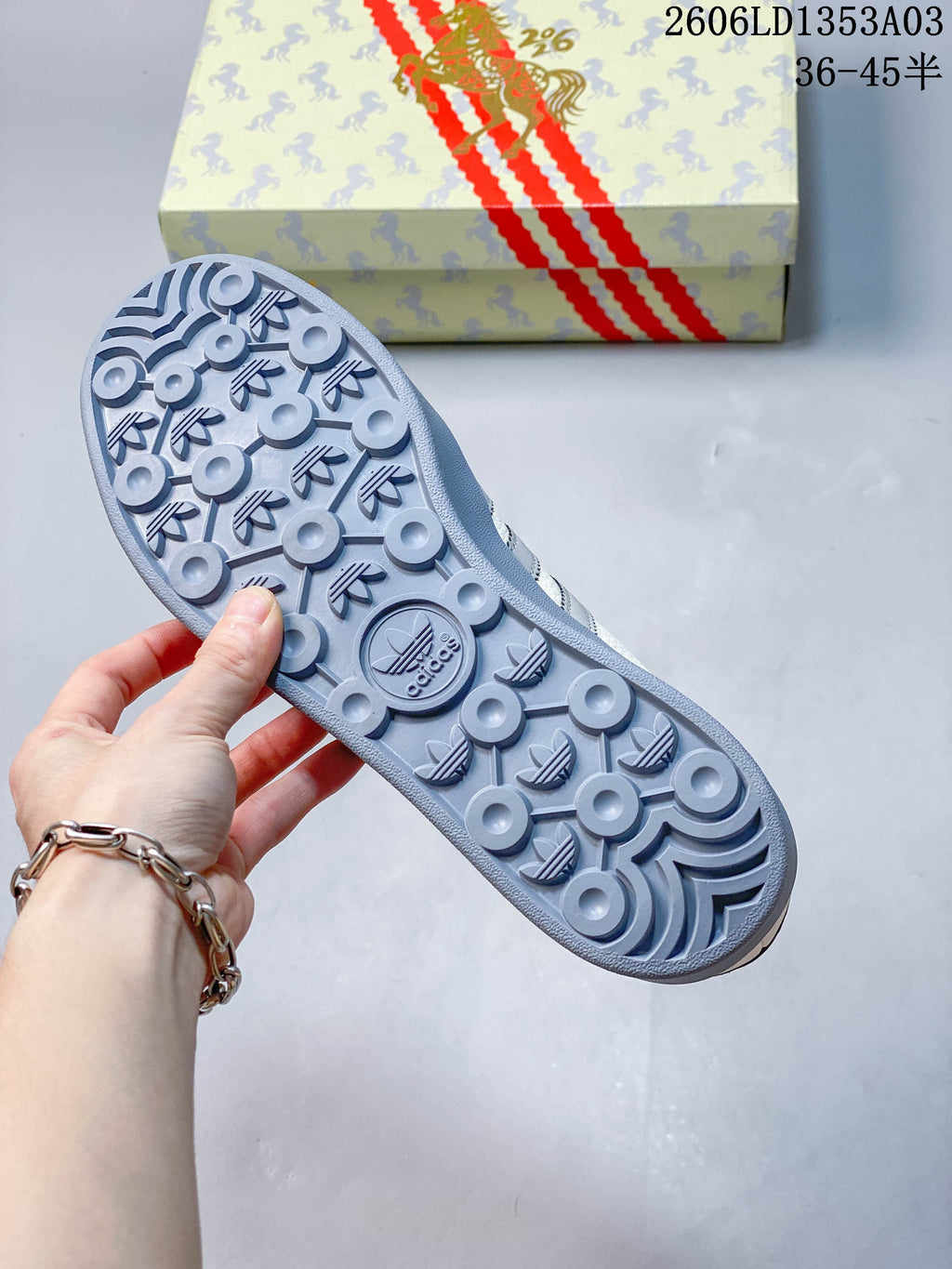 Grey patterned rubber outsole and horse-themed sneaker box