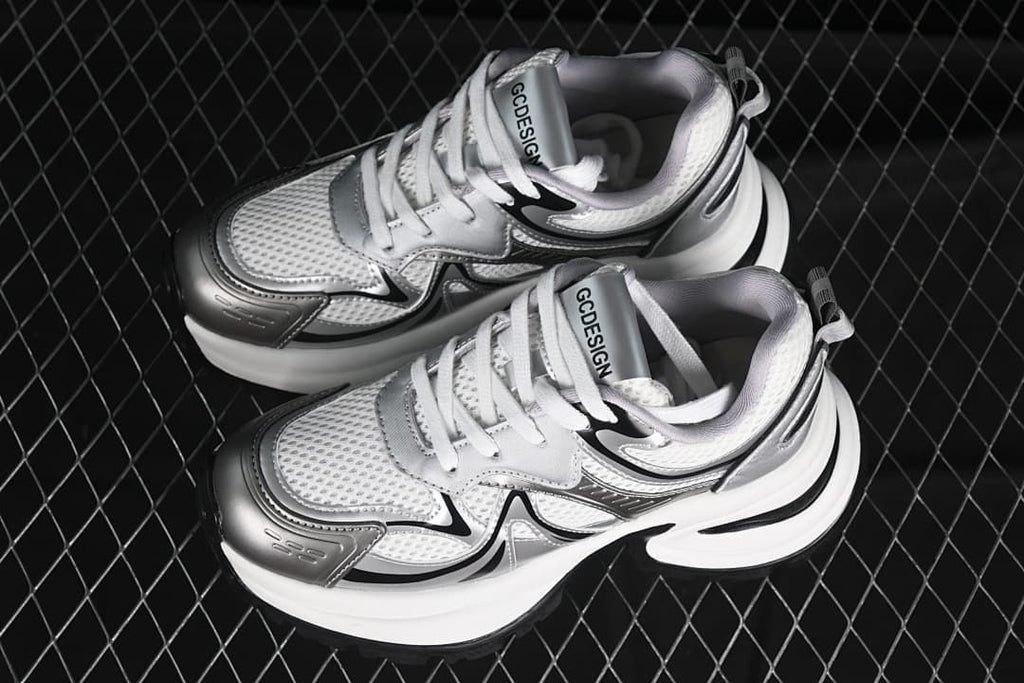 Pair of silver, white, and black GCDS sneakers viewed from above