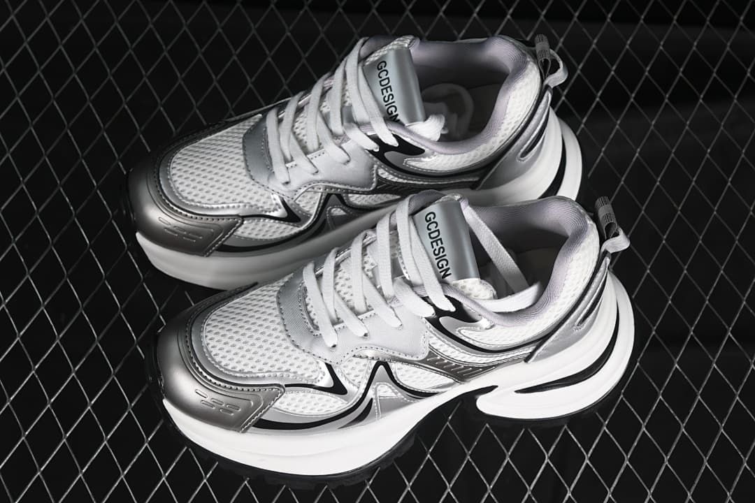 Pair of silver, white, and black GCDS sneakers viewed from above