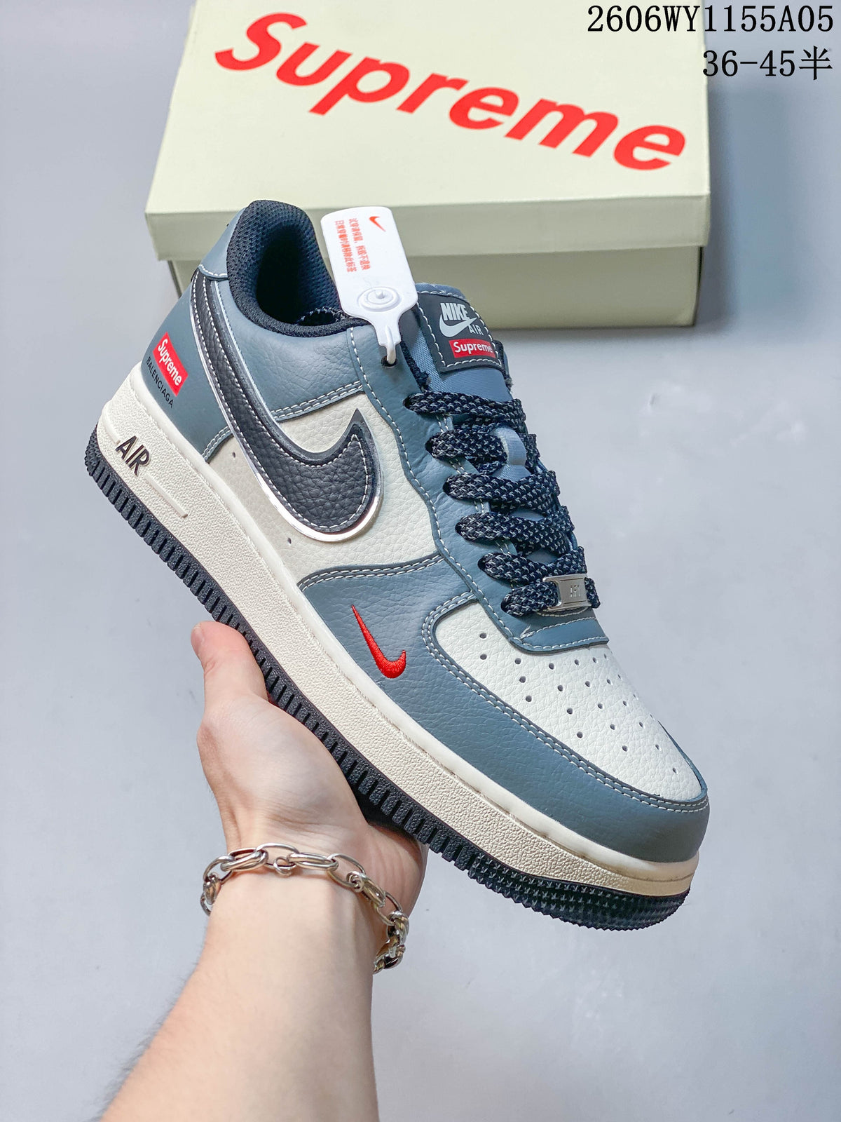 Angled side view highlighting the white and blue panels, dark Swoosh and small red accent.