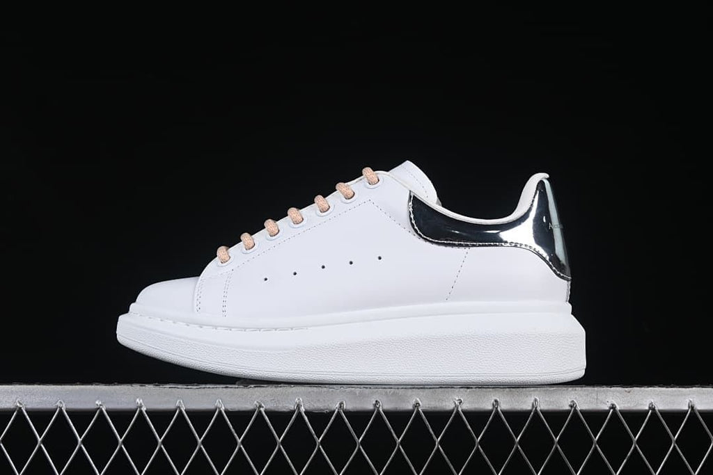 Side profile of the white sneaker with reflective heel detail