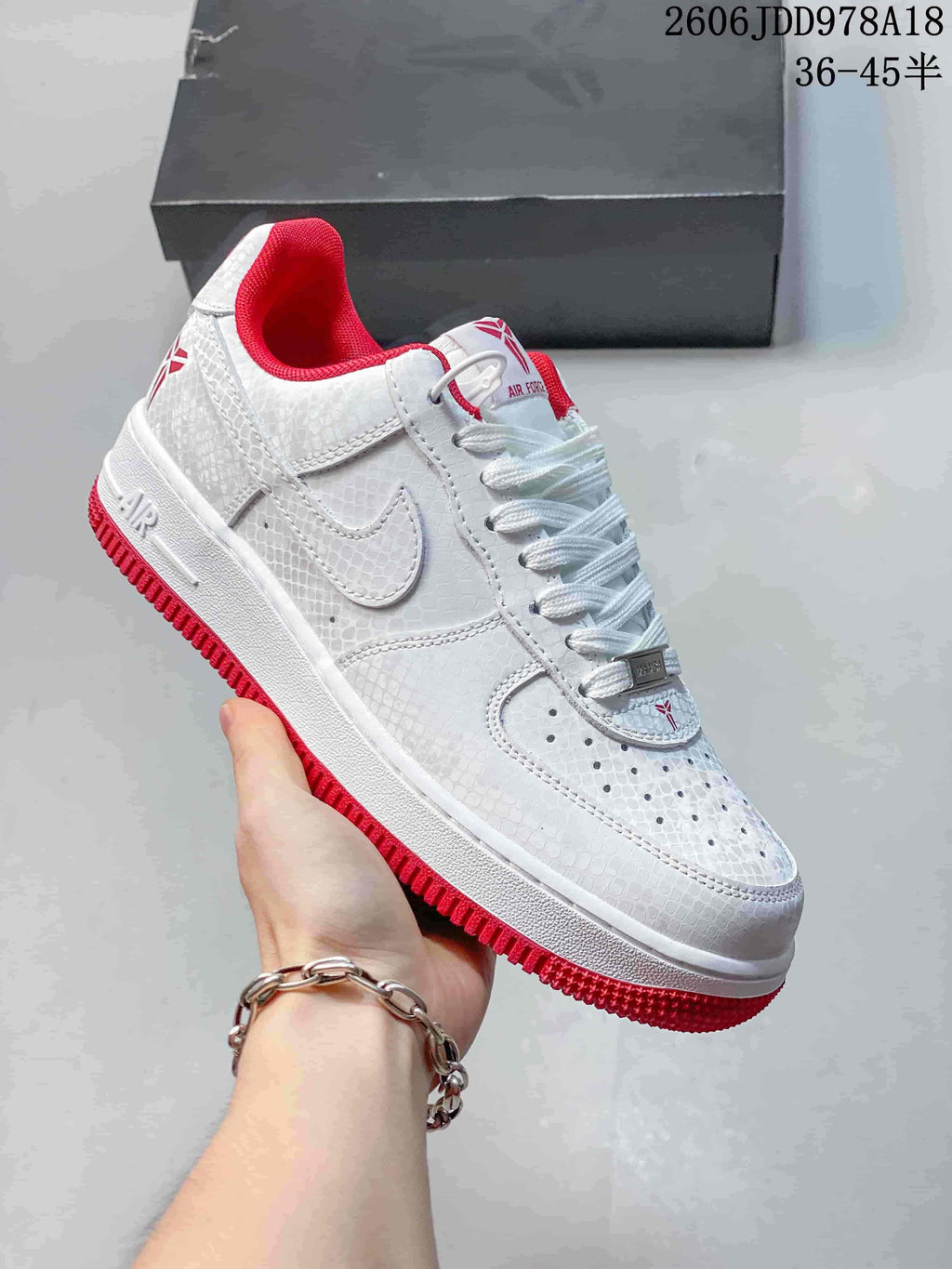 Close-up side view of white patterned low-top sneakers with red accents