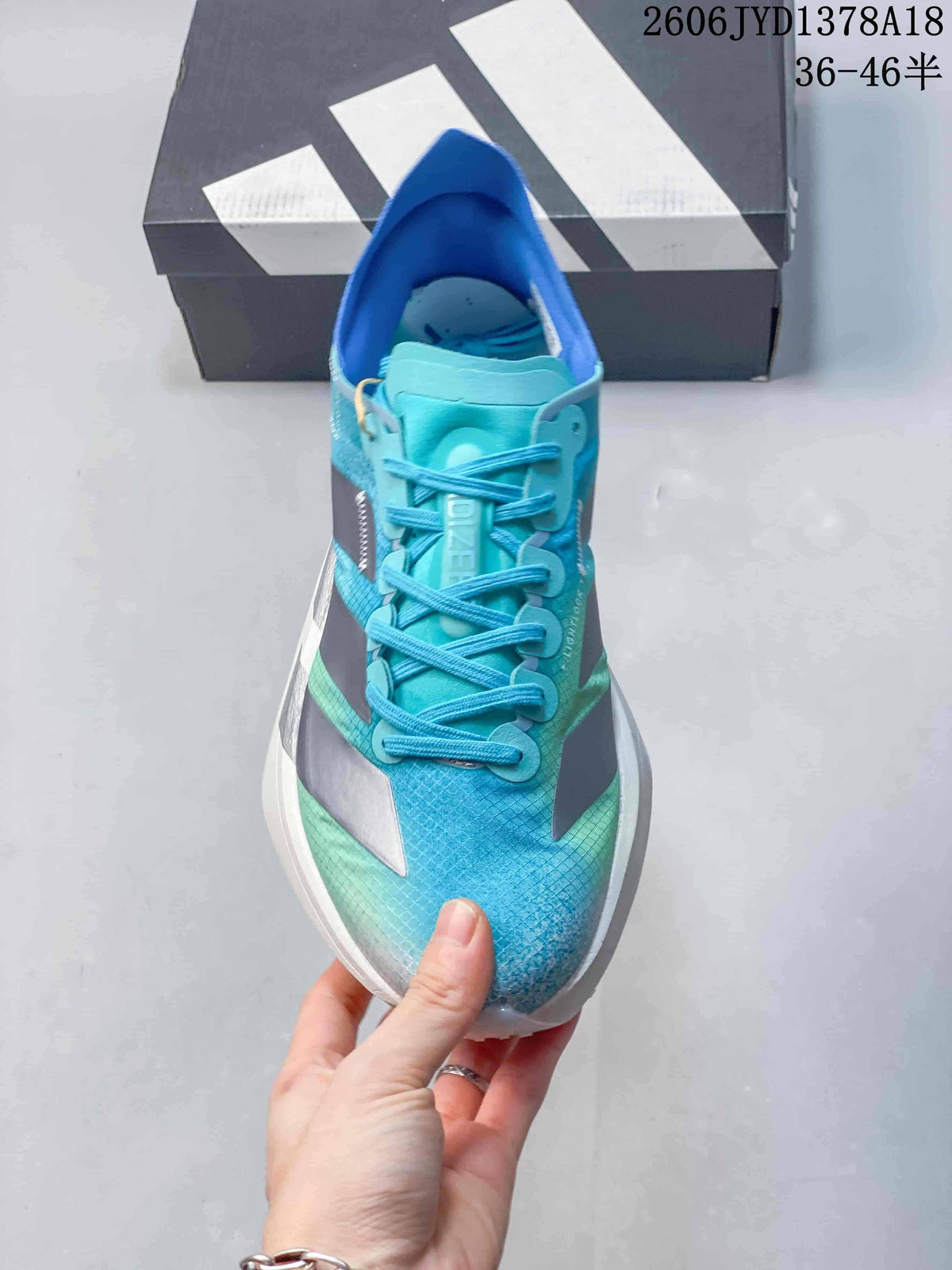 Front view of the shoe showing turquoise laces and a patterned blue upper