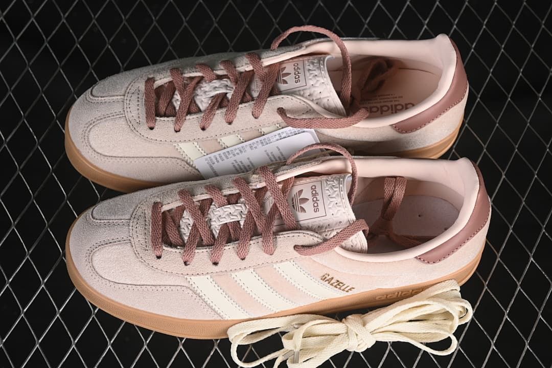 Pair of pink and cream Gazelle Indoor sneakers with an extra lace set