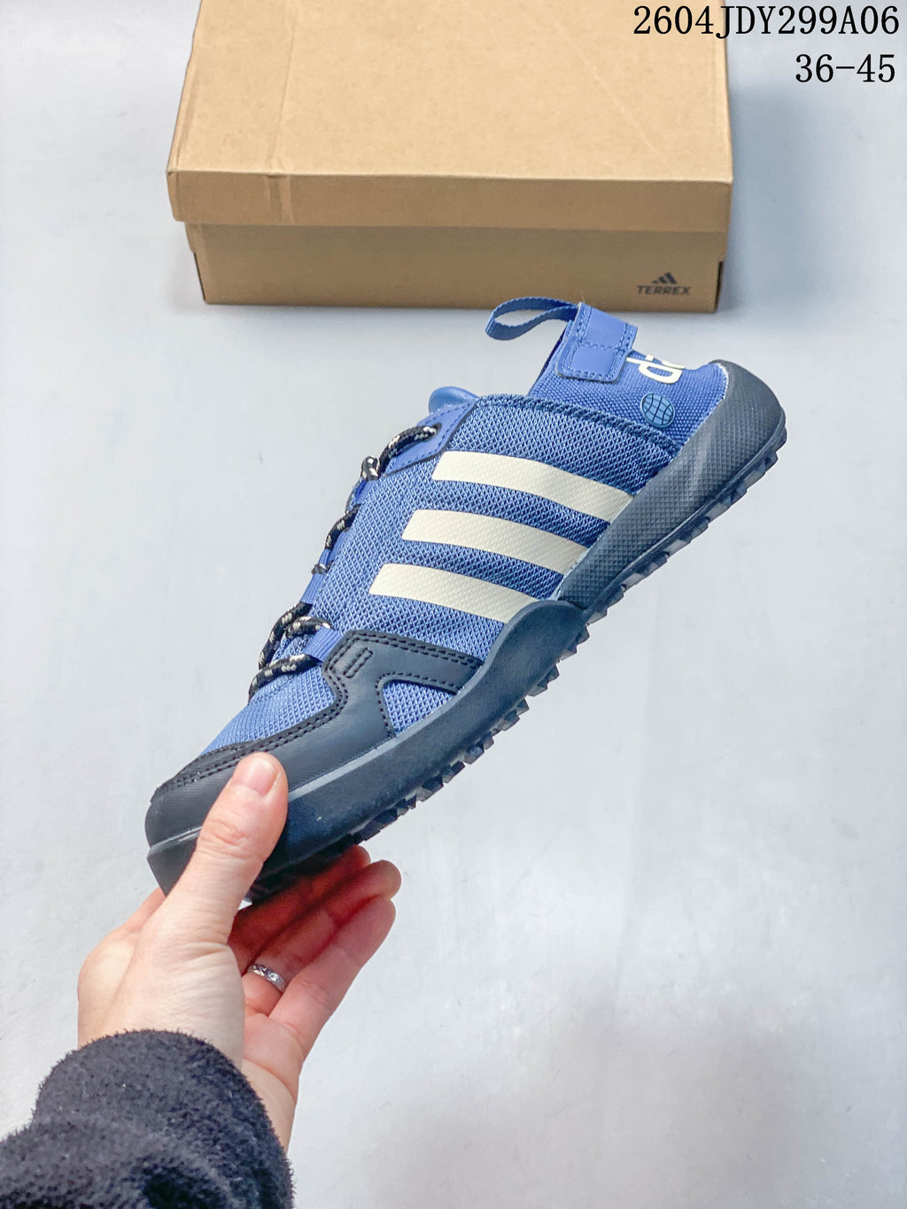 Side view of a blue Adidas outdoor shoe with cream stripes and a lugged sole