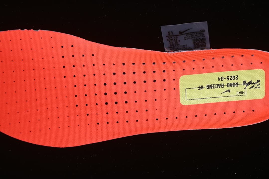 Coral-orange perforated shoe insert with a printed label.