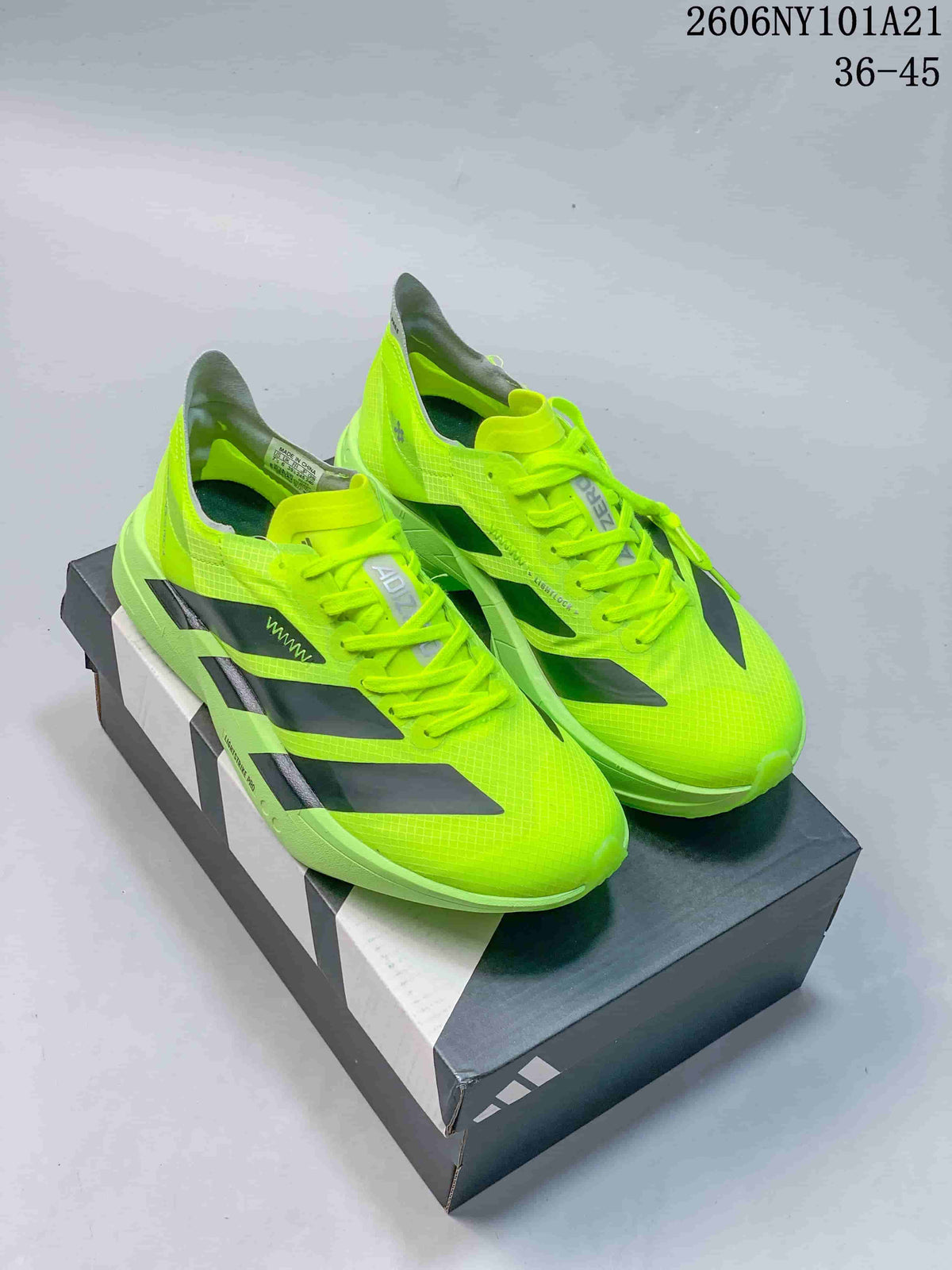 Pair of neon yellow Adidas Ultrabounce shoes on a shoebox; image overlay shows sizes 36–45 and style code 2606NY101A21.