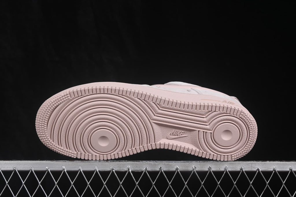 Outsole view showing the circular traction pattern and Nike branding of the pale pink sneaker.