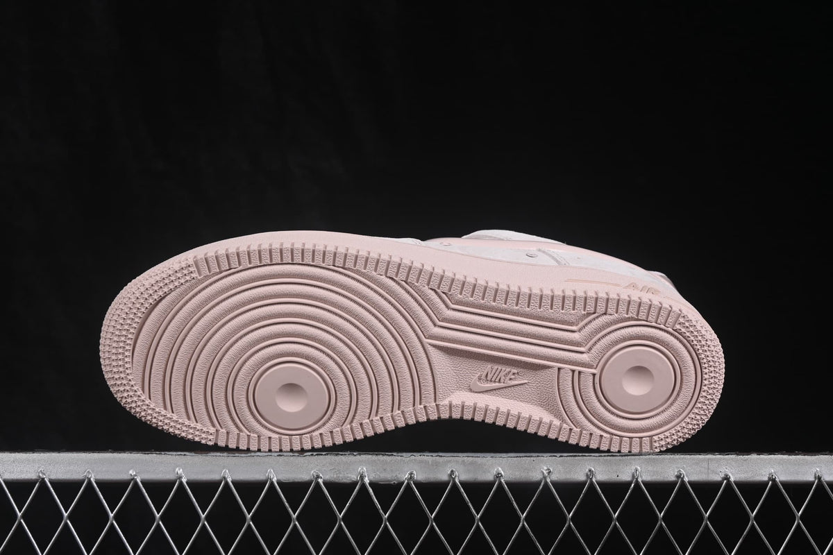 Outsole view showing the circular traction pattern and Nike branding of the pale pink sneaker.