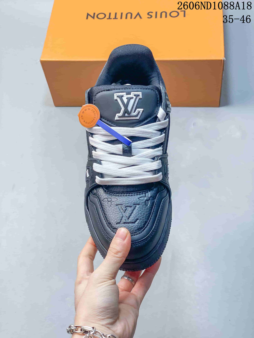 Top view of a navy sneaker showing white laces, tongue logo, and patterned toe panel