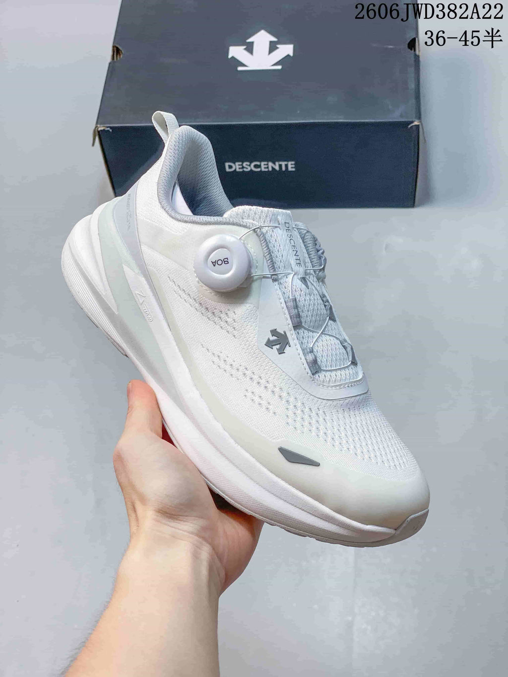 Side view of a white DESCENTE running shoe with a BOA dial closure and thick sole