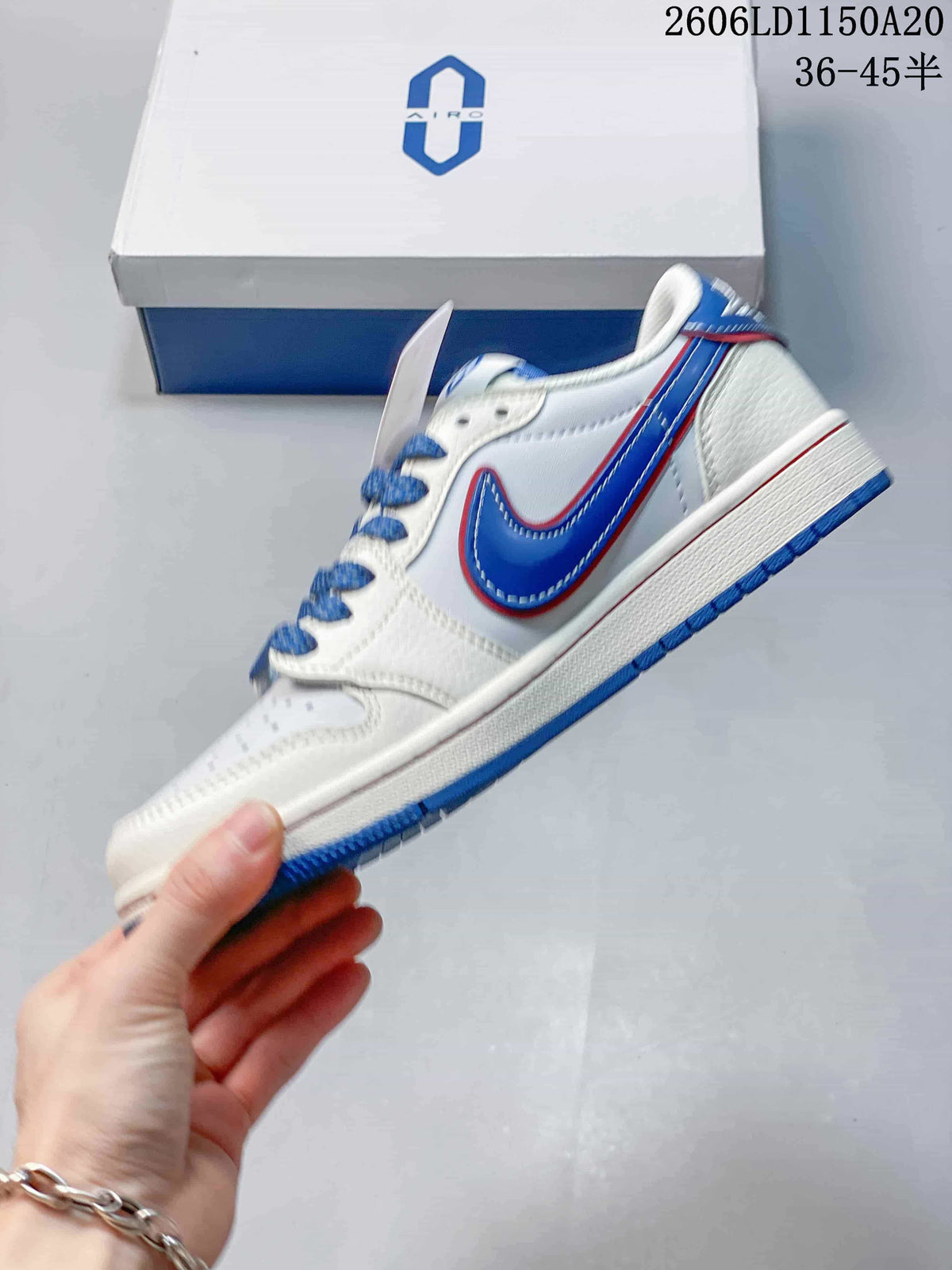 Side view of a white low-top sneaker with a blue swoosh-style panel and red trim.