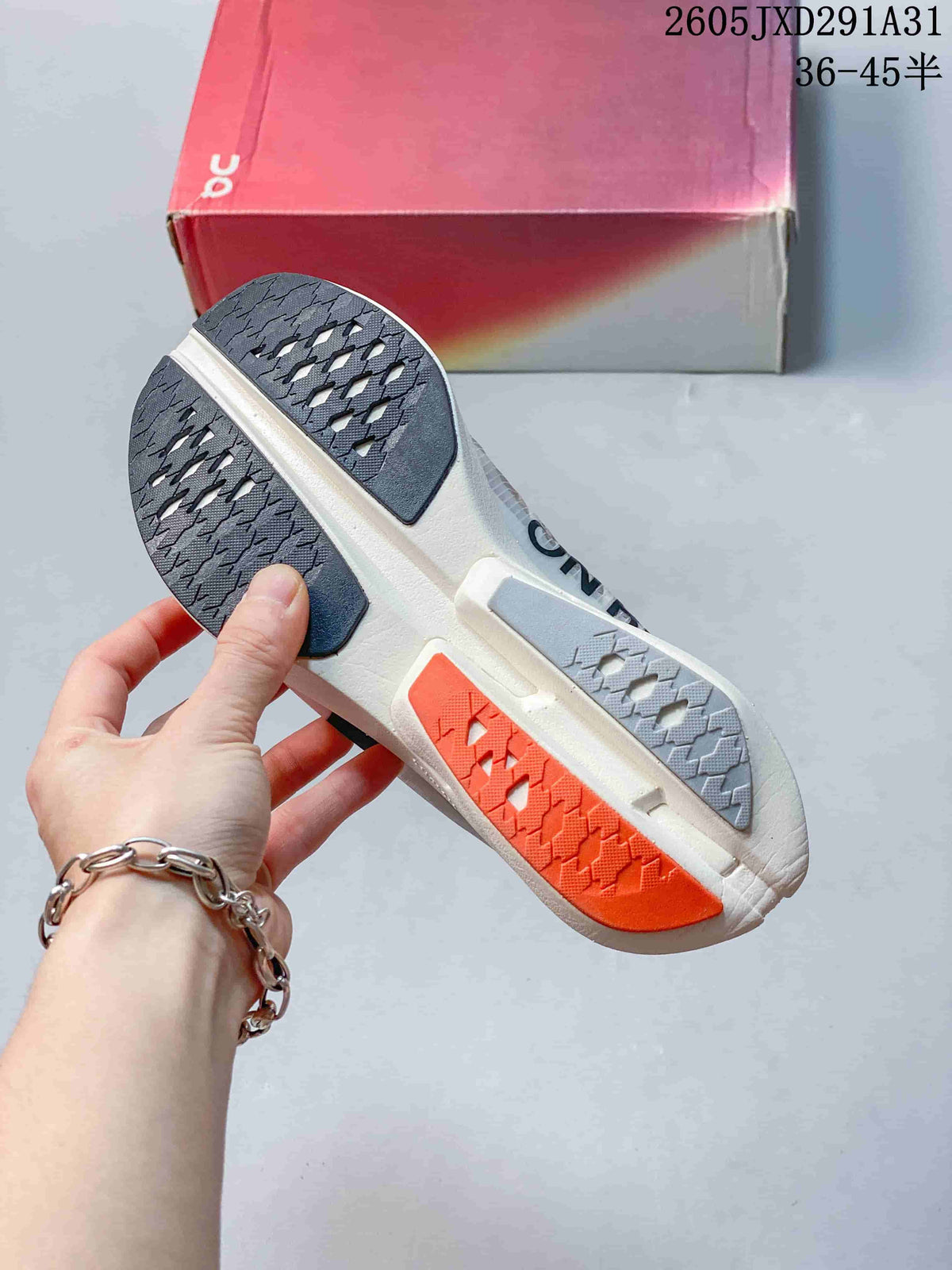 Close-up of the On Cloudboom Strike outsole with contrasting gray and coral tread sections.