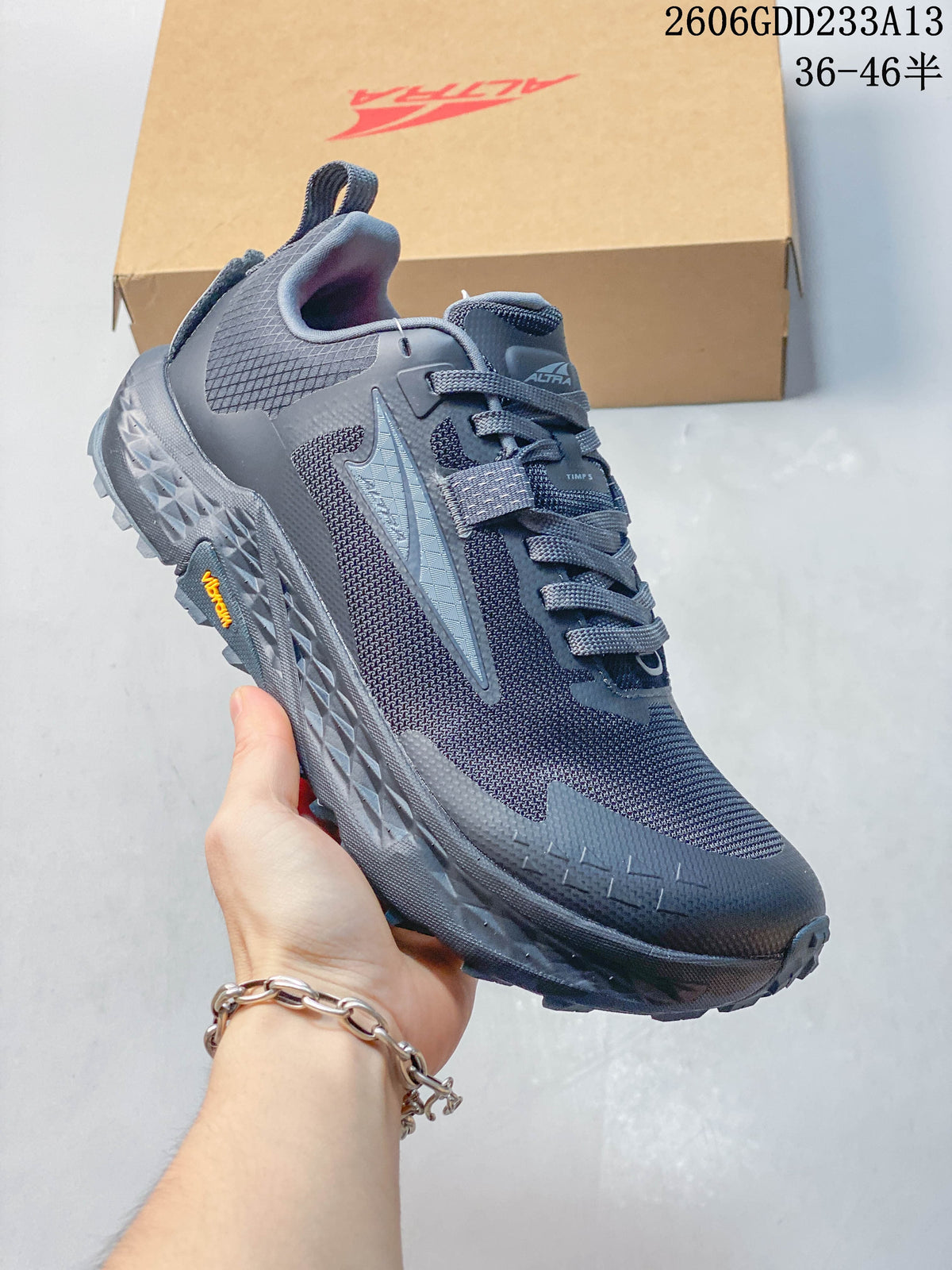Angled side view of the dark gray-blue trail shoe with lugged outsole
