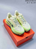 Pair of ivory and volt-green Nike Pegasus Premium sneakers displayed on an orange shoebox