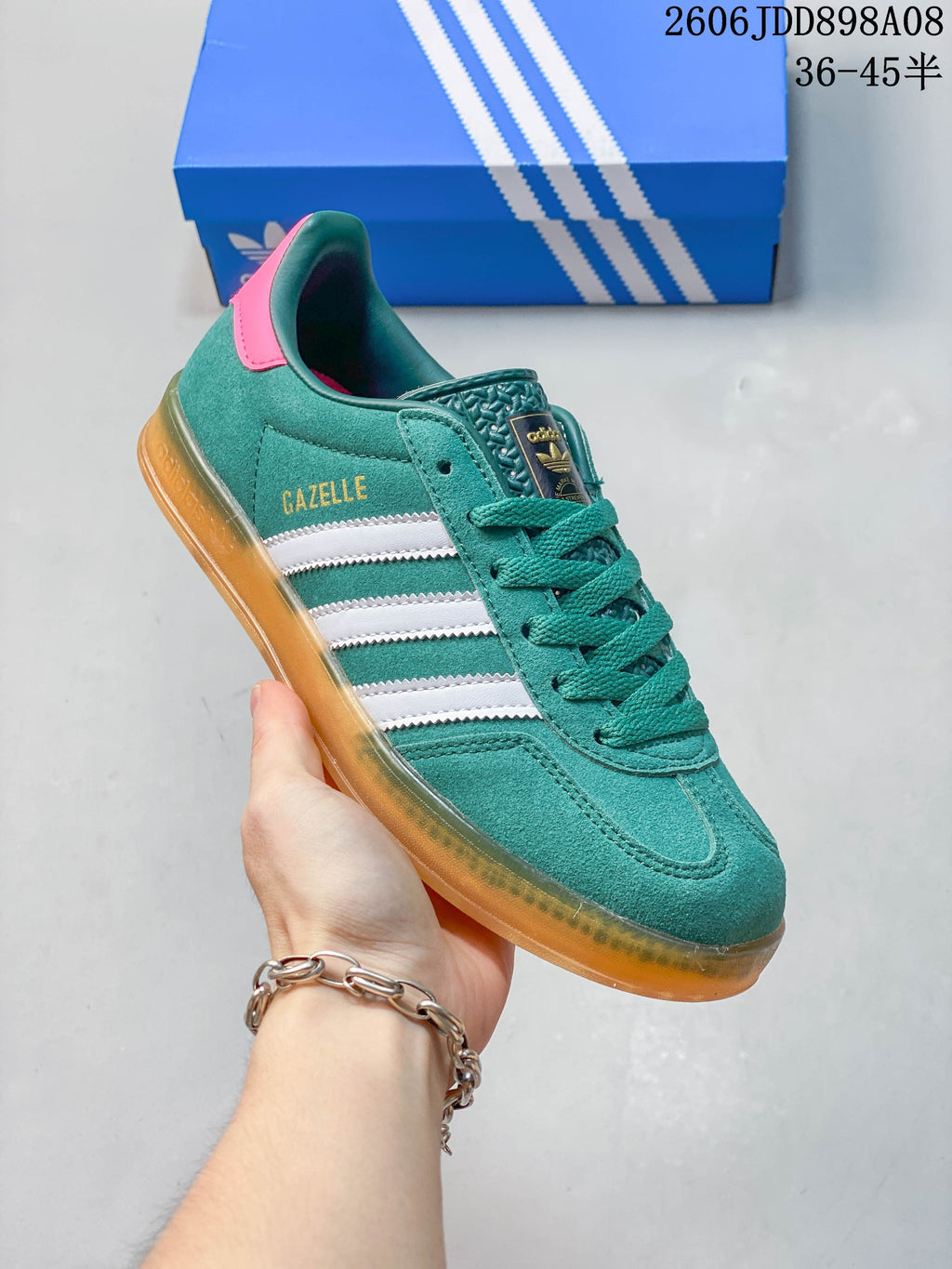 Side view of a teal sneaker showing Gazelle text, white stripes, and a translucent-looking outsole