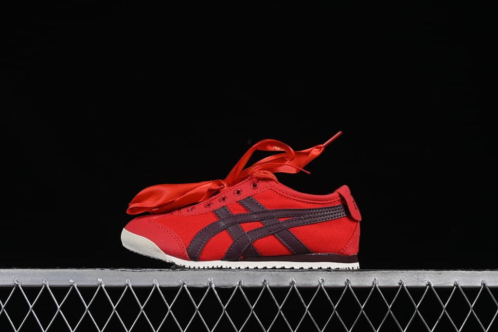 Side view of the red Onitsuka Tiger kids’ sneaker with dark stripes and ribbon laces