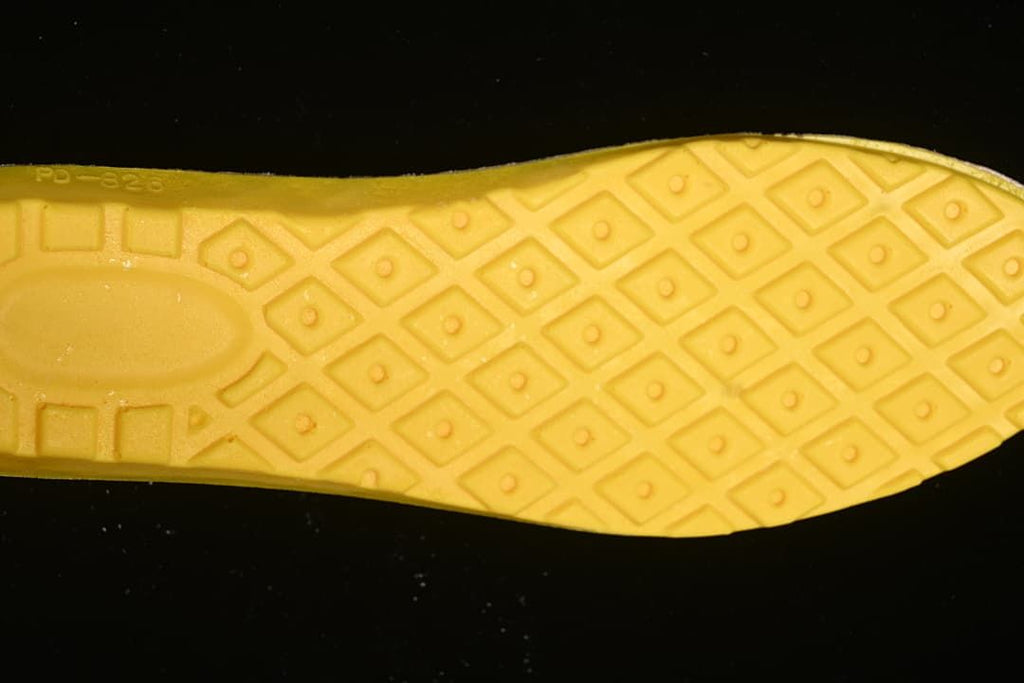 Close-up of the boot's yellow-toned outsole and patterned tread