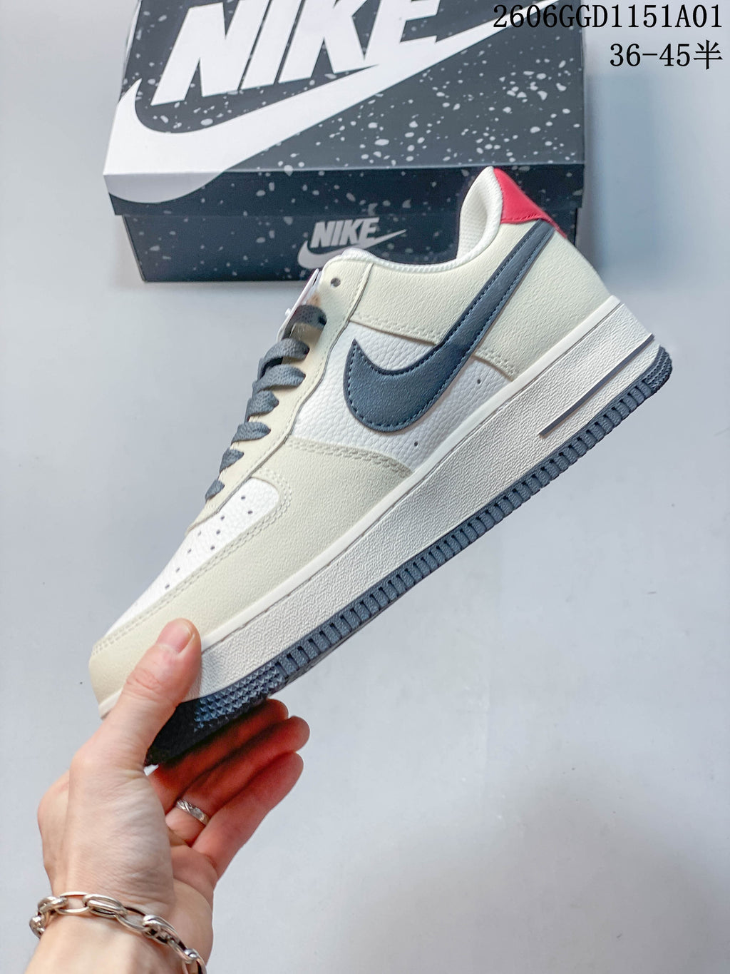 Side view of an off-white Nike Air Force 1 '07 LV8 sneaker with a gray-blue Swoosh and red heel accent.