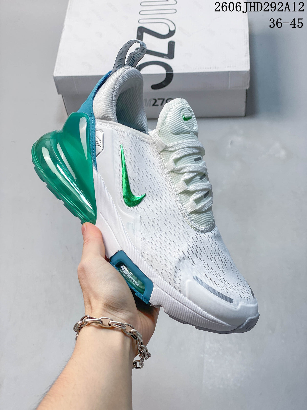Side view of a white Nike Air Max 270-style sneaker with green accents and a translucent green heel unit.