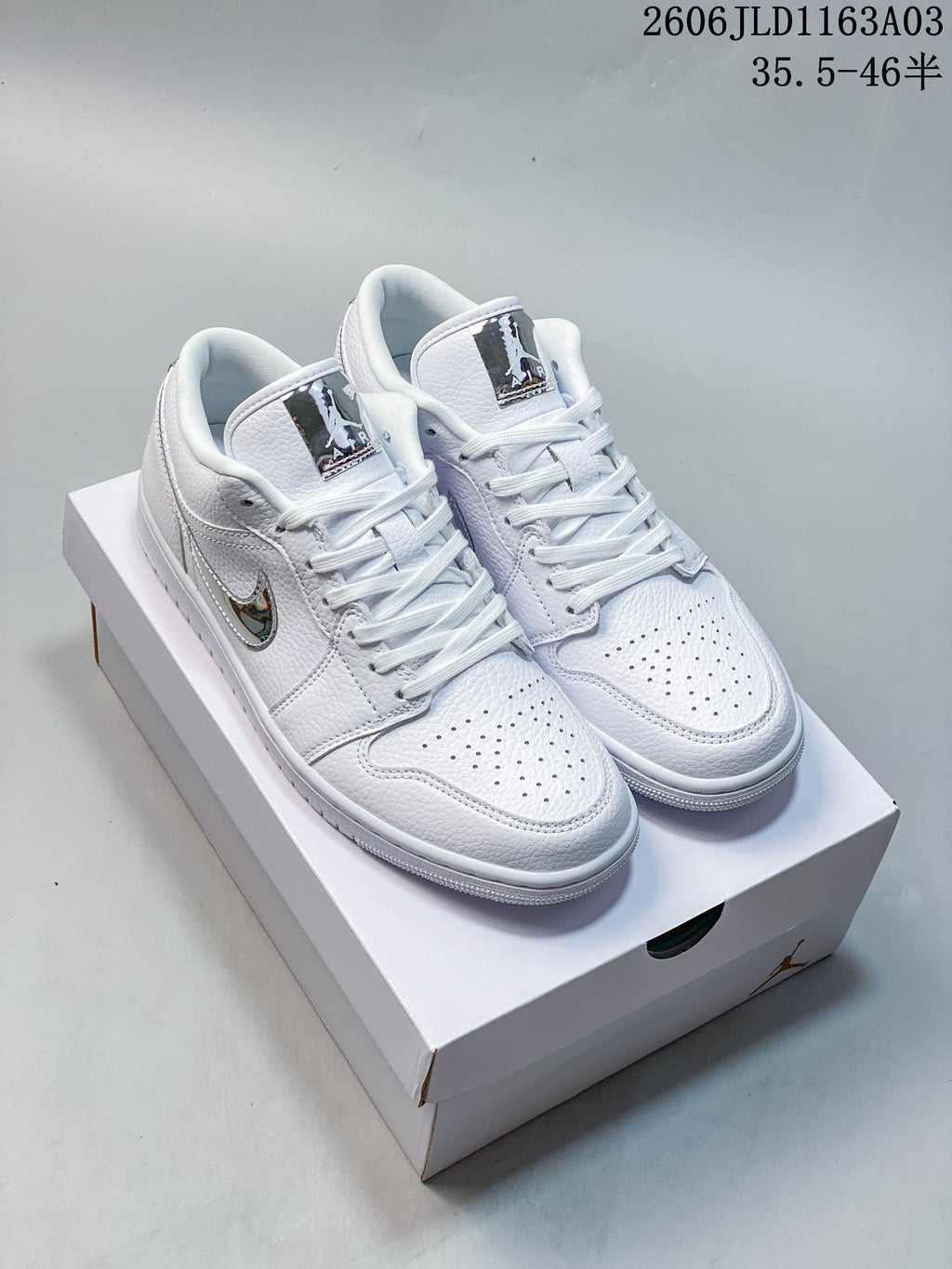 Pair of white Jordan Air Jordan 1 SE low-top sneakers shown from above, with reflective silver-tone details.